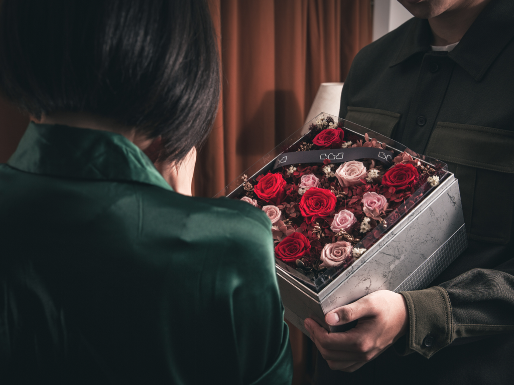 a girl seems happy to receive the flower box 