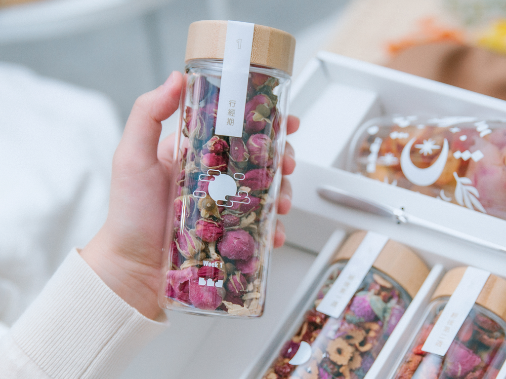 a women pick one bottle of flower tea from the box 